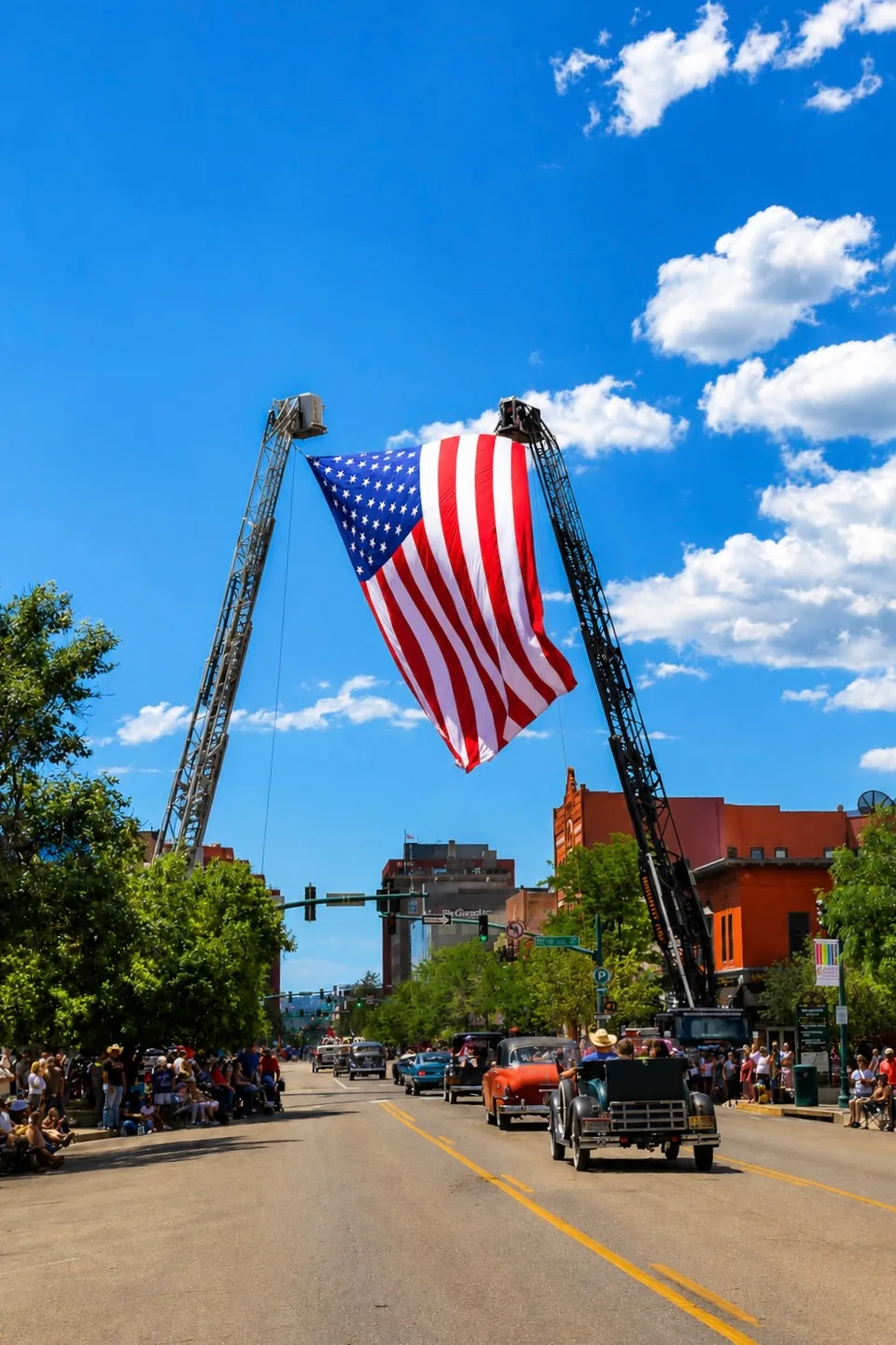Large American flag hanging above a downtown parade route.